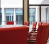 Leerer Konferenz-Tisch mit roten Sesseln